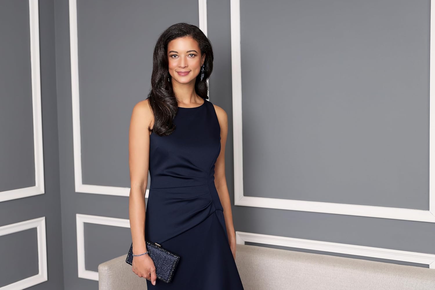 Sleeveless stretch scuba crepe mother of the bride dress in [color] with tucked waist and cascade detail skirt, worn for formal wedding event — view 2